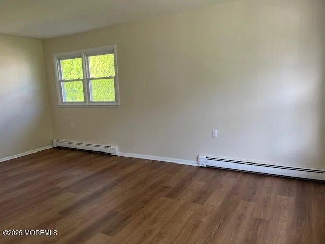 an empty room with wooden floor and window