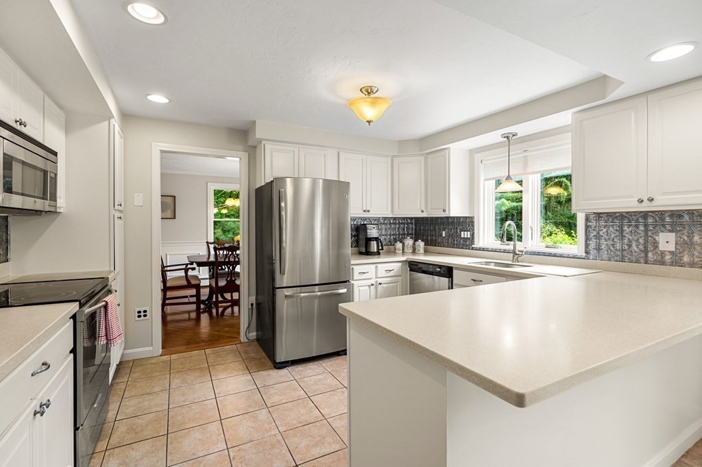 82 Curtis Street Auburn, MA 01501 - Photo 12 of 35 a kitchen with granite countertop a refrigerator and a stove top oven