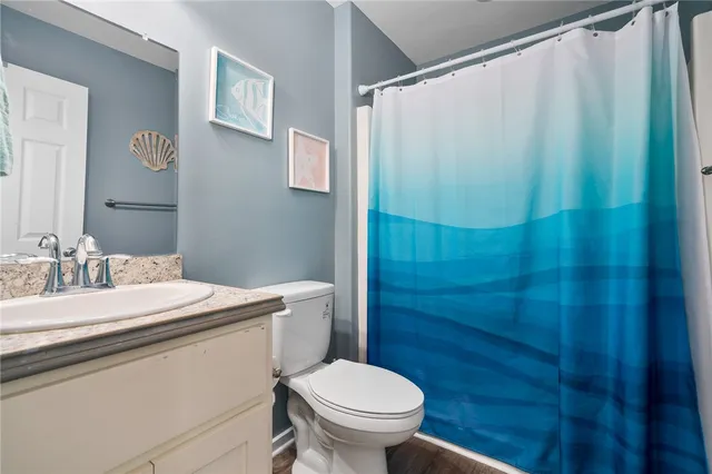 a bathroom with a granite countertop sink toilet and a mirror