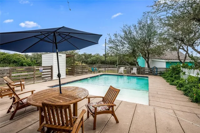 a view of a roof deck with table and chairs under an umbrella