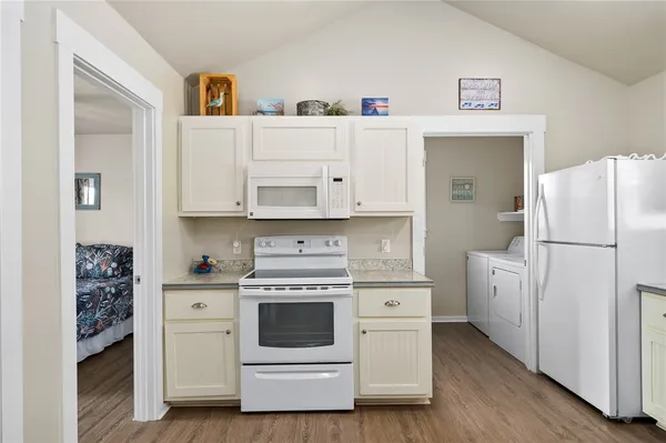 a kitchen with white cabinets and white appliances