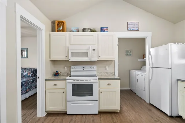 a kitchen with white cabinets and white appliances