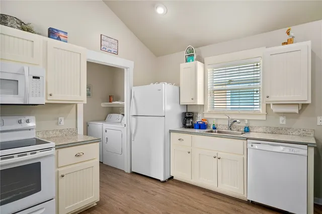 a kitchen with white cabinets sink and white appliances