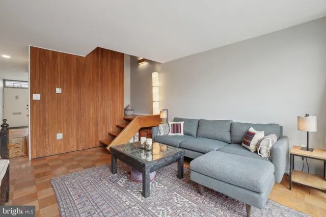 a living room with furniture a rug and a wooden floor