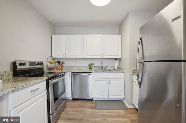 a kitchen with stainless steel appliances granite countertop a refrigerator sink and stove