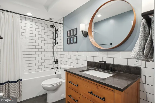 a bathroom with a granite countertop sink mirror and toilet