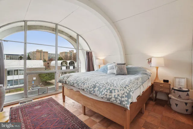 a bedroom with a bed and a large window