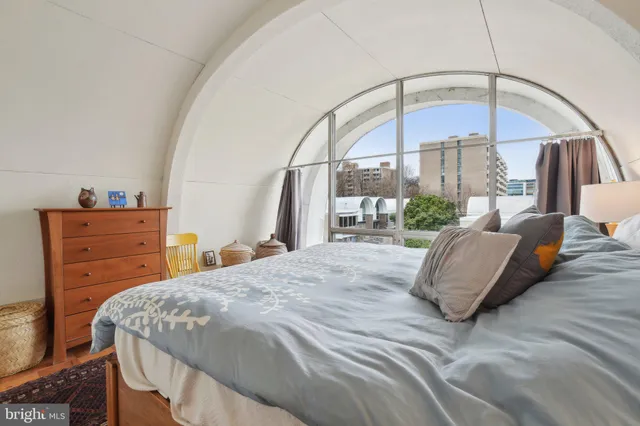 a bedroom with a bed a table and flat screen tv