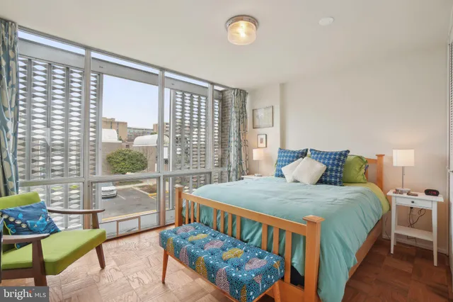 a bedroom with a bed and large windows