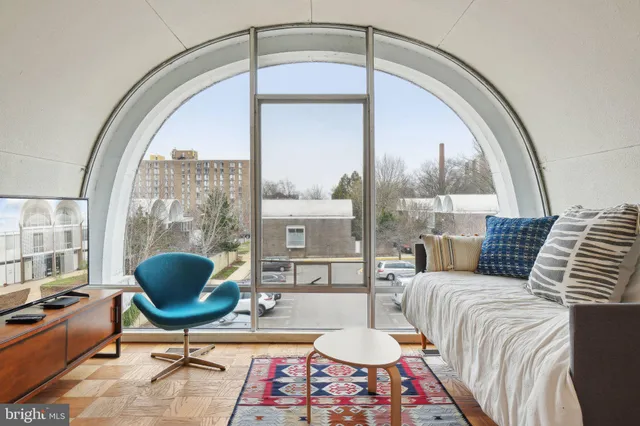 a living room with furniture a table and a large window