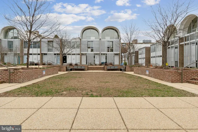 a front view of a building with lot of trees