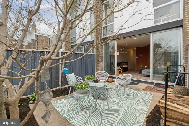 a view of a patio with couches table and chairs and potted plants