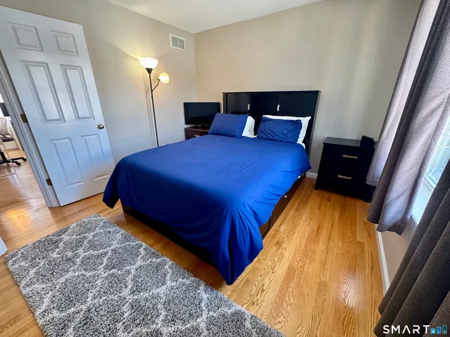 a bed sitting in a bedroom next to a window