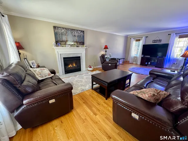 a living room with furniture a flat screen tv and a fireplace