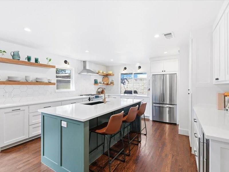 a kitchen with stainless steel appliances a sink and a refrigerator