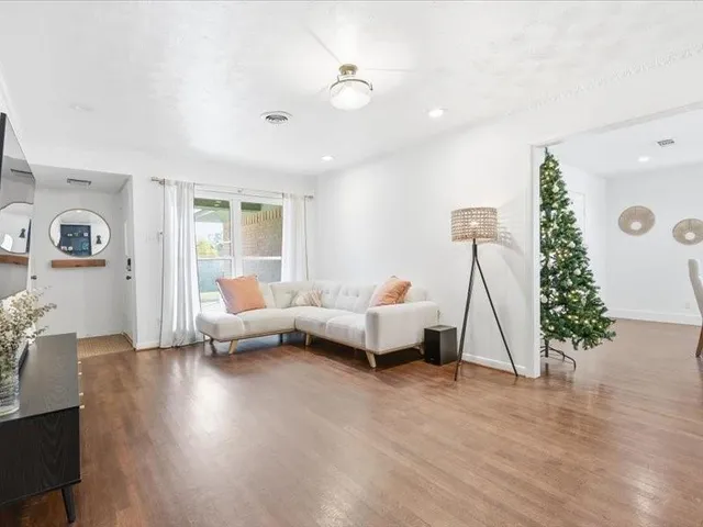 a living room with furniture and a wooden floor