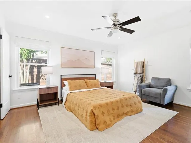 a bedroom with a bed couches and furniture with wooden floor