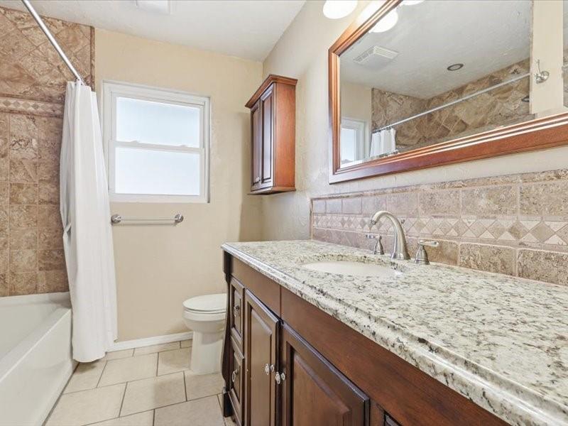 2330 Peavy Place Dallas, TX 75228 - Photo 24 of 39 a bathroom with a granite countertop sink a toilet and bathtub