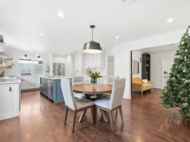 a dining room with furniture a chandelier and wooden floor