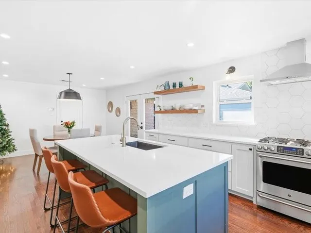 a kitchen that has a sink a stove and a table in it