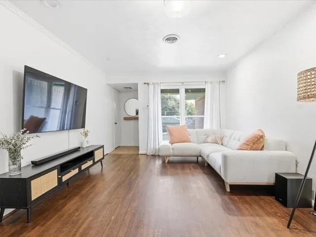 a living room with furniture and a wooden floor