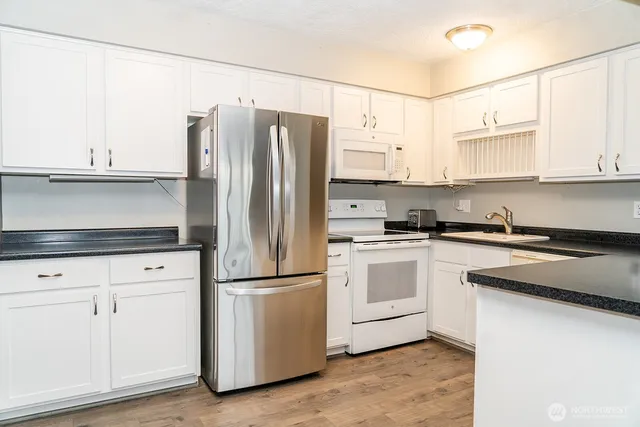 a kitchen with appliances a refrigerator and cabinets