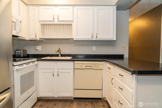 a kitchen with white cabinets and white appliances