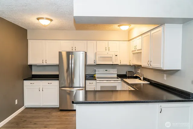 a kitchen with stainless steel appliances a refrigerator sink and cabinets
