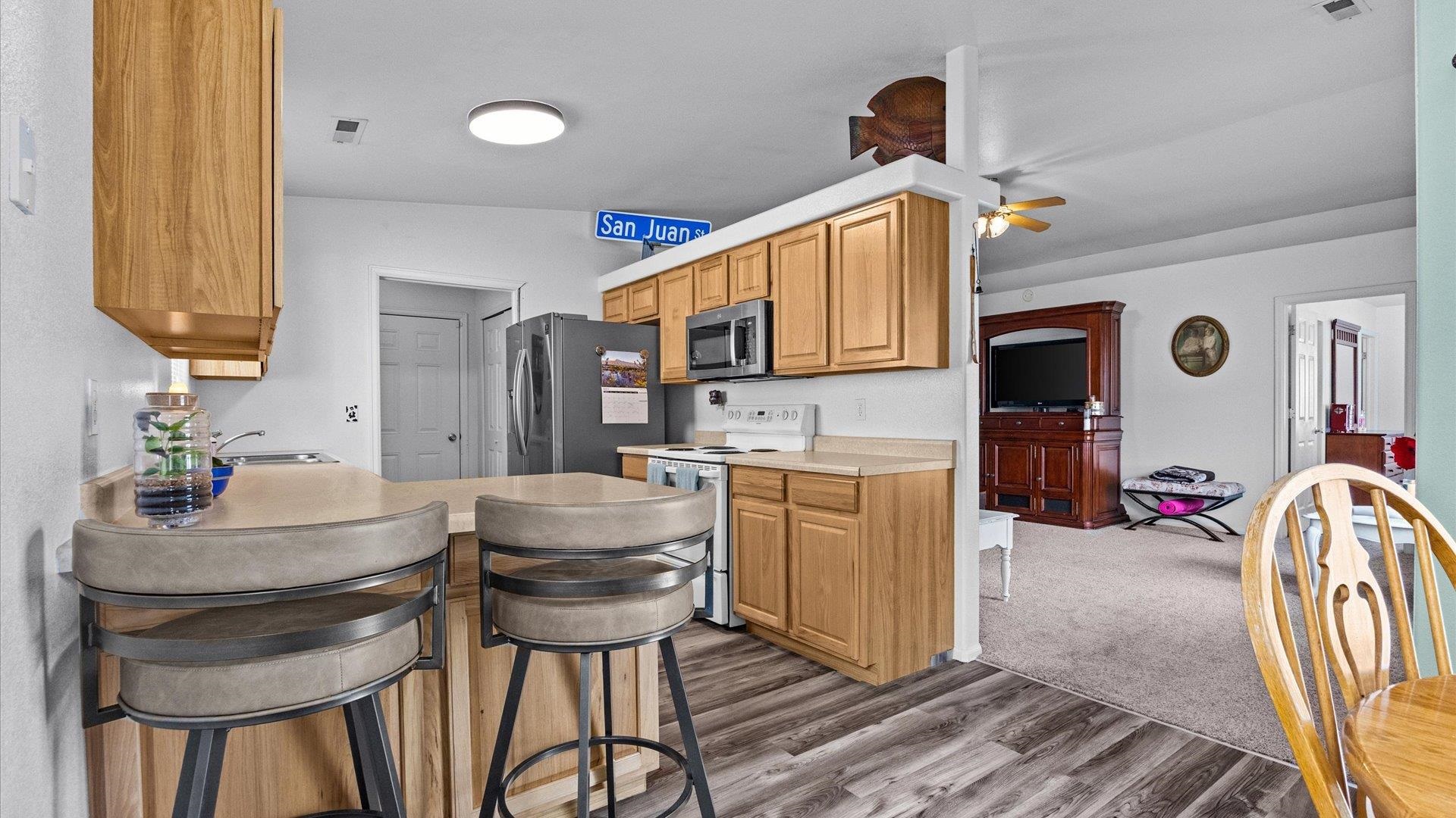 420-29 29 1/2 Road Grand Junction, CO 81504 - Photo 10 of 26 a kitchen with stainless steel appliances kitchen island granite countertop a table chairs in it and wooden floors