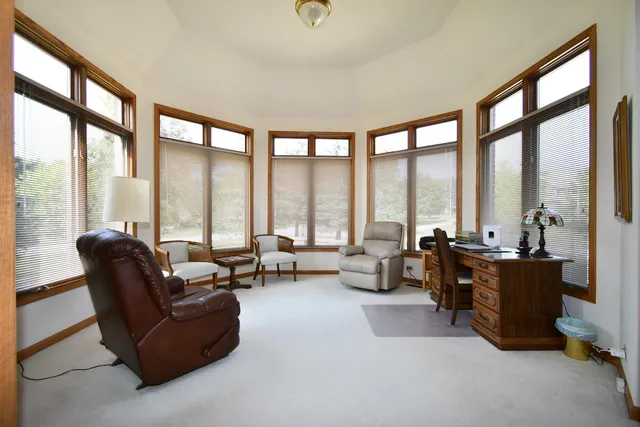 a living room with furniture and floor to ceiling windows