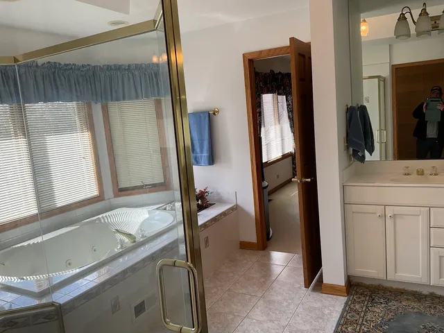 a bathroom with a tub sink a mirror and a shower