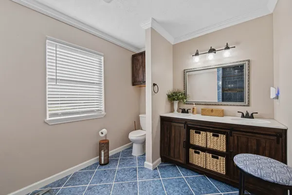 a bedroom with a bed and a dresser next to a window