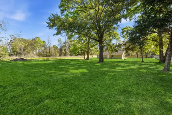 a view of grassy field with benches and trees all around
