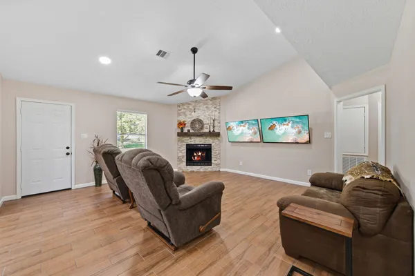 a living room with furniture a fireplace and a flat screen tv