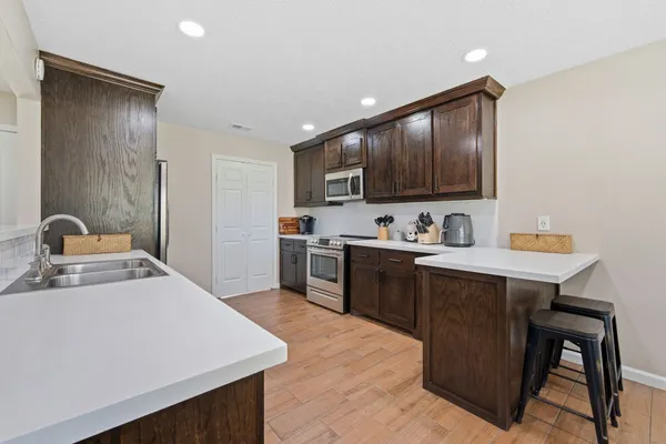 a kitchen with a sink a stove and chairs