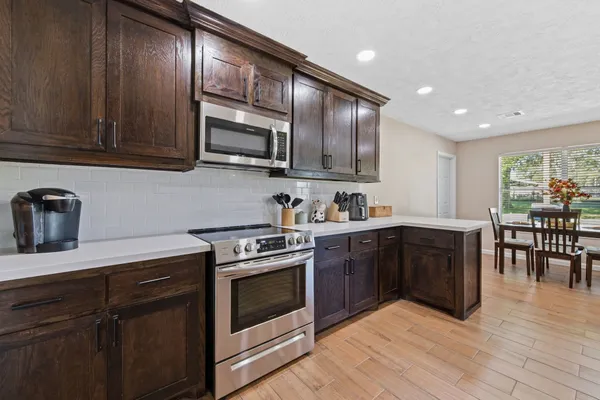 a kitchen with stainless steel appliances granite countertop wooden cabinets a stove top oven a sink and dishwasher