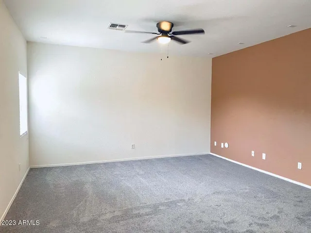 an empty room with a window and a fan