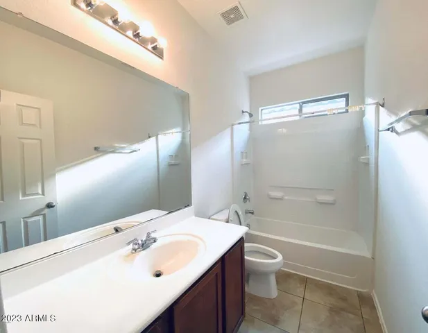 a bathroom with a tub sink and mirror