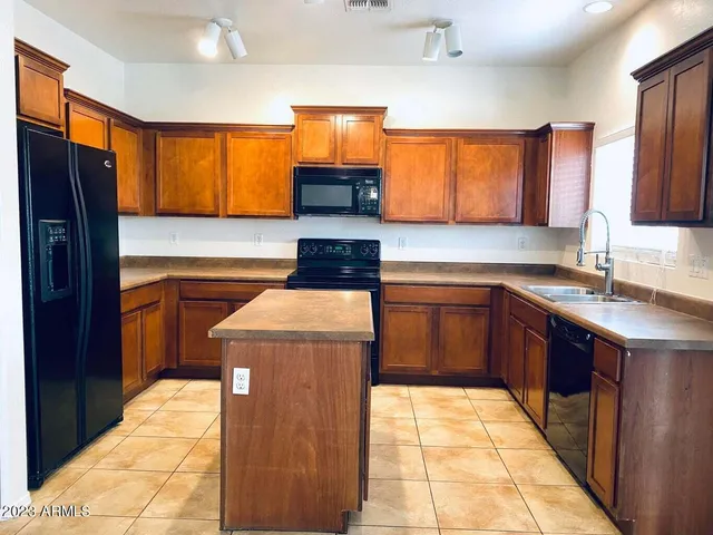a kitchen with stainless steel appliances granite countertop a stove a sink and a refrigerator