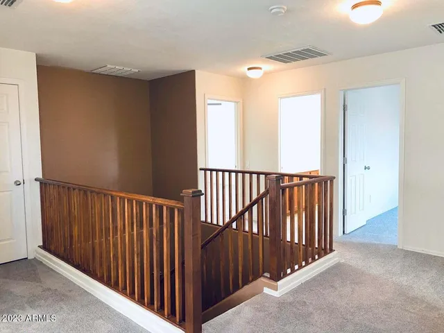 a view of a hallway with wooden floor and windows