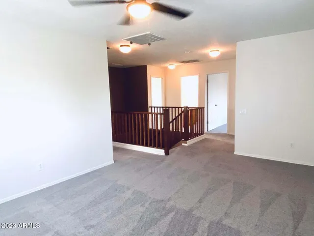 an empty room with closet and a ceiling fan