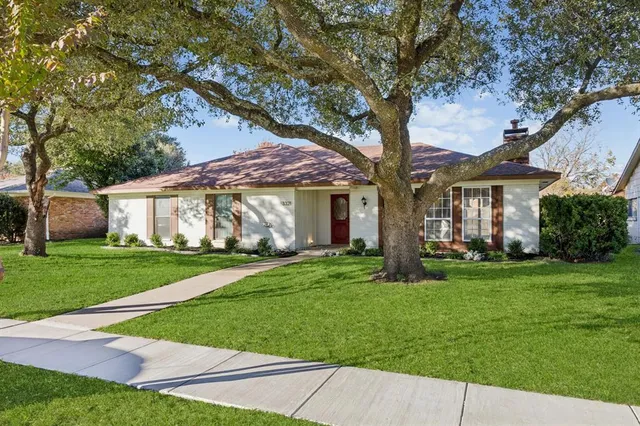 a front view of a house with a garden and yard