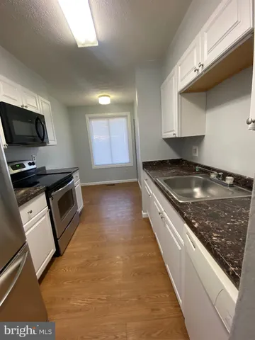 a kitchen with stainless steel appliances granite countertop a sink a stove and a microwave