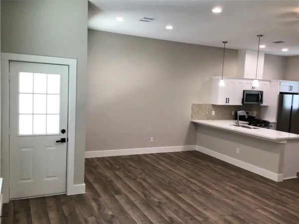 a view of kitchen with wooden floor and electronic appliances
