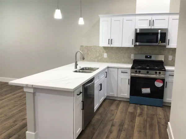 a kitchen with a sink stove and microwave