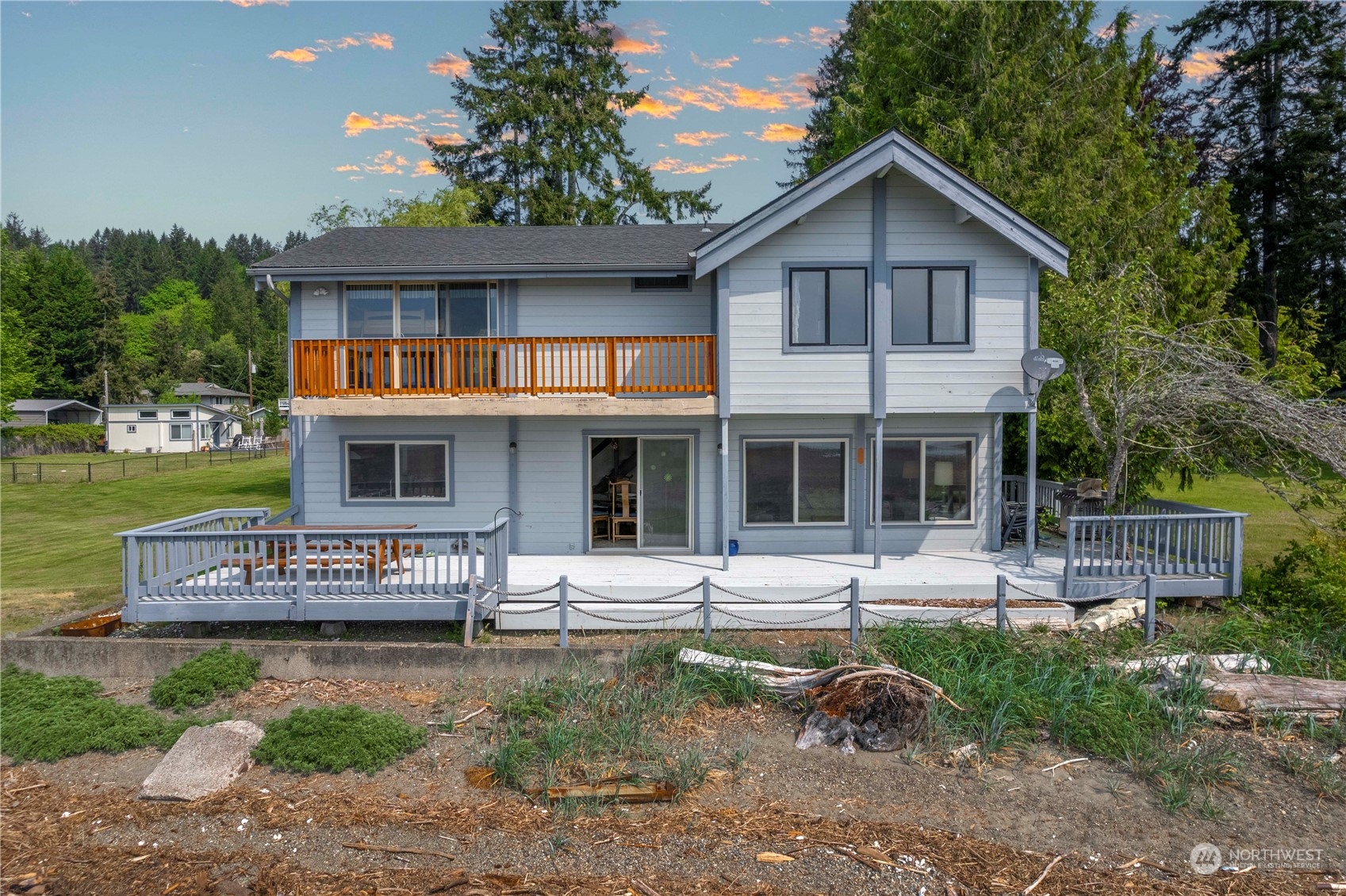 191 Northeast Wagon Wheel Road Belfair, WA 98528 - Photo 2 of 27 a front view of a house with a yard table and chairs