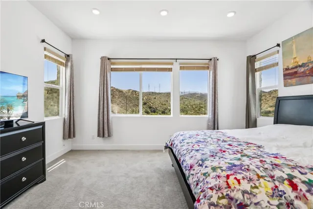 a bedroom with a bed and a large window