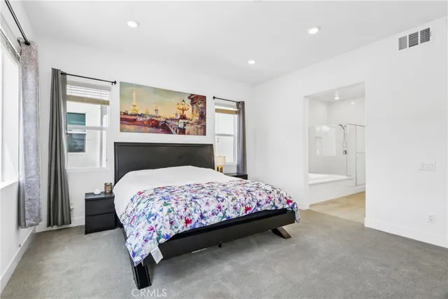 a bedroom with a bed and painting on the wall