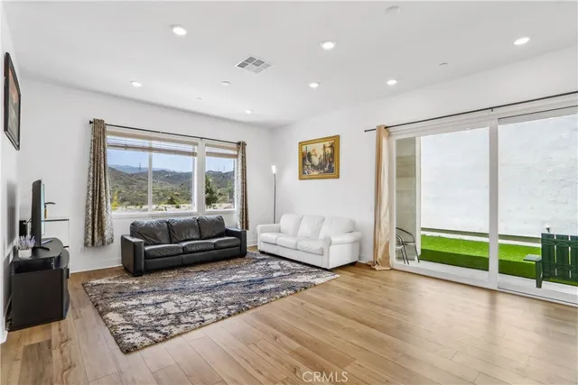 a living room with furniture and a floor to ceiling window