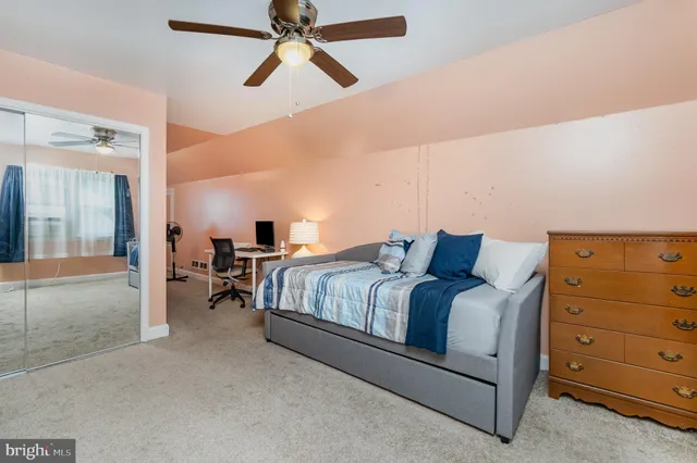 a bedroom with a bed and ceiling fan